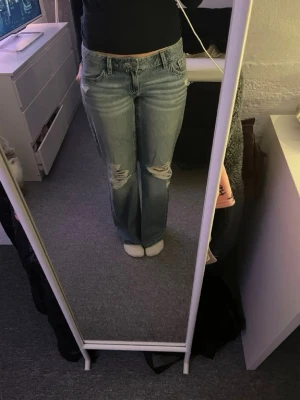 Blå baggy jeans från Gina 14+ - Säljer ett par ljusblå gina jeans med baggy passform och slitna detaljer på knäna. Klassisk femficksmodell med låg midja och snygga V-formade bakfickor. Jeansen är gjorda i jeansmaterial och har en avslappnad vibe. De två första bilderna är inte mina. Helst nya använda två gånger.