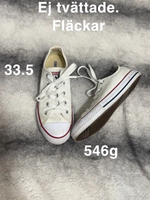 Converse All Star vita sneakers 33.5 - Säljer ett par klassiska Converse All Star sneakers i vitt med röda och blå detaljer. Låga med rund tå, snörning och platt sula. Perfekt för dig som gillar ikoniska och stilrena sneakers.🌸 Sparsamt använda. Ej tvättad. Fläckar. Storlek 33.5