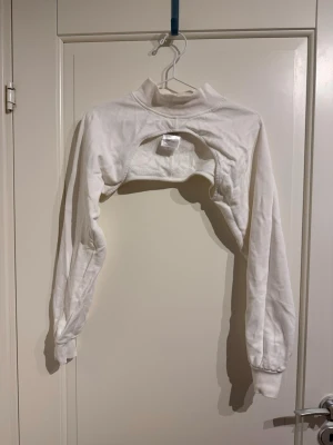 Vit croppad sweatshirt från Gina Tricot - Säljer en vit croppad sweatshirt från Gina Tricot i storlek XS. Tröjan har långärmade ärmar, ribbad hög krage och muddar vid ärmslut.