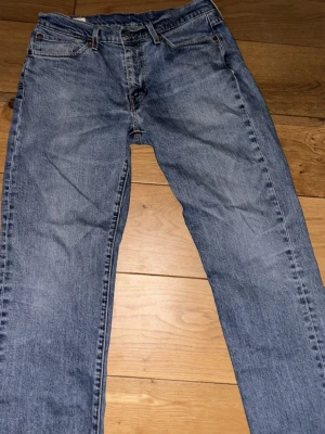 Levi's jeans - Levi's 514 jeans straight fit. Jeansen är i bra skick med undantag av konstgjorda slitningar som gjorts vid hälen som visas på bilden. Storlek 32/34 för vidare funderingar tveka inte att fråga!