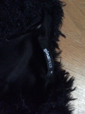 Svart pälsjacka från Gina Tricot - Säljer en svart fluffig pälsjacka från Gina Tricot i storlek XS. Jackan har en cool och trendig look med mjuk pälsimitation som ger extra edge till outfiten. Perfekt för dig som vill sticka ut och hålla dig varm med stil.