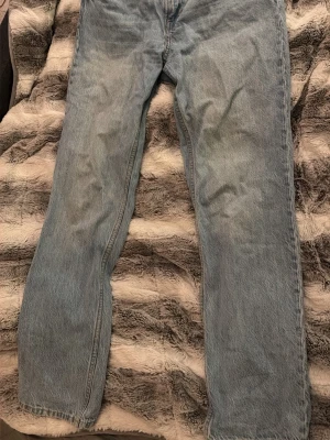 Straight jeans i ljusblå denim från H&M - Säljer ett par straight fit jeans från H&M i ljusblå denim i storlek 42. Femficksmodell med raka ben och normal passform. Jeansen har knapp och dragkedja framtill. Perfekt för dig som gillar enkel och clean stil. 💗