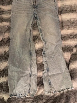 Ljusblå wide/straight jeans från Divided - Säljer ett par ljusblå jeans från Divided i storlek 42. De har en bred passform med raka ben och femficksdesign. Jeansen har en cool tvättad look som ger en avslappnad vibe. Perfekta för dig som gillar loose och bekväma jeans.😁