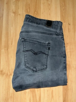 Replay jeans - Säljer ett par Replay skinny jeans i mörkgrå tvätt. Jeansen har låg midja och är tillverkade i stretchig bomullsdenim. Midja 34cm, längd 101cm. JAG SKICKAR EJ FLER BILDER NÄR JAG BÄR JEANSEN! för bättre inblick i passformen rekommenderar jag att googla på modellnamnet. För storleksguide kolla måtten noggrant då jeansen alltid kan vara uppsydda heller krympta och jag ej tar emot returer :) 1,8