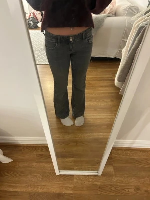 Bootcut jeans Gina Tricot - Snygga grå jeans från Gina Tricot i storlek 152. Modellen har låg midja, bootcut-ben. Jeansen har dubbla silverknappar och dragkedja framtill. Materialet är mjukt denim i bomull. Jag säljer jeansen för att de blivit försmå och förkorta i benen (jag är 157), skriv gärna om ni har frågor och priset är diskuterbart 💕jeansen tvättas innan jag skickar iväg dom 💕