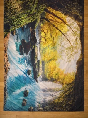 STOR VÄGBODNAD med naturmotiv GROTTA MÅTT 2,20 X 1.40 M - 🫶Snygg fräsch Vöggbodnad med ett stort tryck av ett naturmotiv som visar en grotta  skog  och en forsande flod i blått, grönt och gult. Mått 2.20Meter x1.40 METER och är tillverkad i ett syntetiskt material som känns lätt och smidigt. Perfekt för dig som vill få hem naturen.  Leveranstid 2-3 vardagar. Kontakta mig gärna innnN köp 