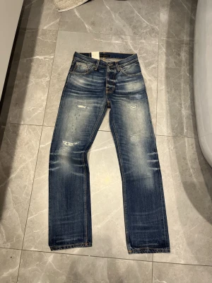 Nudie jeans Loose Leif Selvedge - Säljer dessa sjukt snygga helt nya nudie selvedge jeansen. Dom är i modellen loose Leif och sitter straight. De är i storleken 27/30 men sitter lite större. Skriv vid minsta fråga/fundering👌Midja: 36,5 cm, Längd: 103 cm, Benöppning: 19 cm