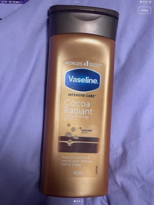 Vaseline Cocoa Radiant Body Lotion 400ml - Vaseline Intensive Care Cocoa Radiant är en body lotion med kakaosmör och Vaseline Jelly. Flaskan är bronsfärgad med brunt lock och rymmer 400 ml. Ger huden glow och återfuktar utan att kännas fet. Perfekt för dig som vill ha mjuk och återfuktad hud.
