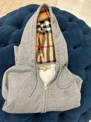 Grå Burburry kofta🩶 - Hej! Säljer min riktigt stiliga burburry kofta. Säljer en väns. | Storlek: M/modellen är 1.80| Lite defekt på ena armen/ Smuts. Äkthetsbevis tillkommer ~DMa💥