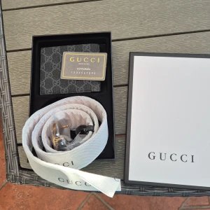 Gucci GG Supreme bälte 105cm plus plånbok. - Säljer ett Gucci GG Supreme bälte i grått med klassiskt monogrammönster och stor guldfärgad GG-spänne. Bältet är gjort i skinn och har exklusiv känsla, perfekt för att lyfta vilken outfit som helst.