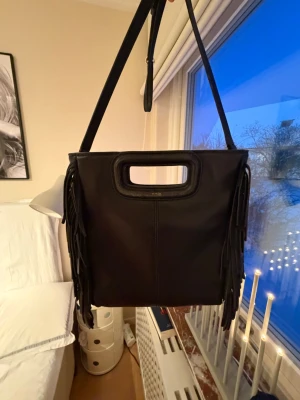 Svart axelväska i skinn från Maje - Säljer en väska från Maje i lite större variant där man får plats med fler saker. Den är ganska använd men funkar bra. Pris kan diskuteras💞