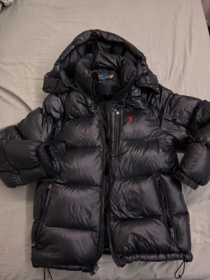 Ralph Lauren - Gorham Glossed Dunjacka - Säljer min dunjacka från Ralph lauren. Använt den en vinter och vill sälja den då jag köpt en annan jacka. Köpt via zalando och Kvitto finns om önskas. Jackan är i princip ny skick. Priset kan diskuteras 