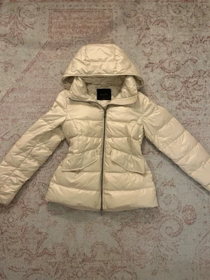 Massimo dutti puffer jacka - Snygg beige pufferjacka från Massimo Dutti med huva och dragkedja framtill. Inte tillgänglig längre med nypris på 1300kr, säljer för 1000kr. Pris går att diskutera
