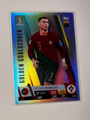 Match Attax Ronaldo EM 2024 - Snygg mörkrött fotbollskort med gula detaljer och nummer 7 på bröstet. Västen har en sportig look med inslag av grönt och gult, samt ett tryckt klubbmärke på vänster sida. Perfekt för dig som gillar fotboll.