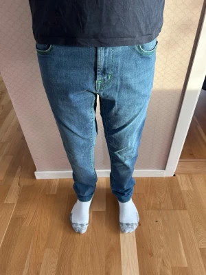 Blå jeans från Tramarossa med gröna sömmar - Hej och välkommen till BL nu säljer vi ett par tramarossa jeans i mycket bra skick endast en defekt och de ser man på bild 3!! Mvh BL 
