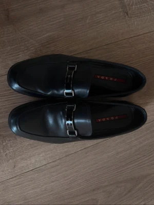 Prada loafers svarta  - Säljer ett par stiliga prada loafers då jag skaffat ett par nya. Skorna är använda men annars i bra skick tveka inte att meddela vid vidare funderingar :)