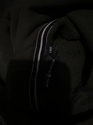 En mörkgrön sailracing hoodie - En snygg mörkgrön sailracing hoodie som bara är använd några fåtal gånger. Hoodien har en stor ficka i mitten. De finns inga hål eller något liknande på tröjan. Perfekt för barn som gillar streetwear.
