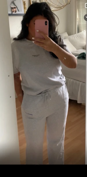 Grå set från Axel Arigato - Säljer ett par grå mjukisbyxor från Arigato med snörning i midjan. Byxorna har en avslappnad passform och är tillverkade i mjukt bomullsmaterial. Perfekta för chill dagar hemma eller när du vill vara extra bekväm. T-shirt och mjukisbyxor 500kr. Storlek L