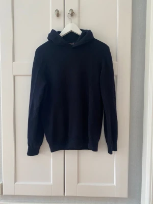 Mörkblå hoodie i kashmir från Oscar Jacobson herr  stl S - Mjuk och stilren mörkblå hoodie från Oscar Jacobson stl S. 48 % ull, 30% viskos, 15 % nylon och 7% Kashmir. 