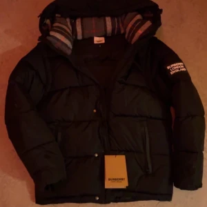 Svart pufferjacka från Burberry - Svart pufferjacka från Burberry helt ny, kan byta med en canada gosse bor i Stockholm 