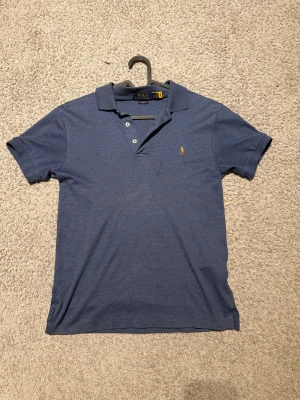 Blå Polo Ralph Lauren piké slim fit XS -XXS - Snygg blå pikétröja från Polo Ralph Lauren i slim fit-modell. Klassisk krage, korta ärmar och två knappar framtill. Oklart vilken storlek det är men jag skulle säga att det passar som en XS. Pris går att diskutera.