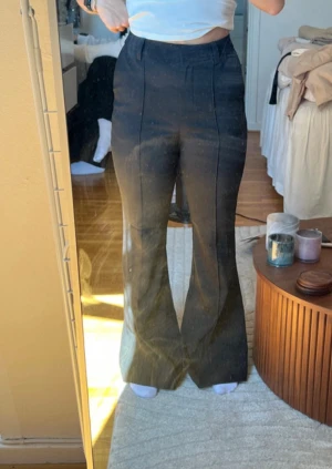 Svarta bootcut kostymbyxor NA-KD - Snygga svarta kostymbyxor från NA-KD i bootcut-modell med hög midja. Byxorna har pressveck framtill, bälteshällor och klassisk stängning.