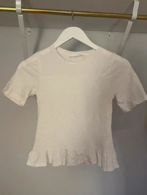 Vit blus med volangkant - Söt vit blus/tshirt med volangkant nedtill💗 Priset kan diskuteras!
