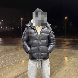 Svart Moncler pufferjacka med huva - Förste till kvarn! Svart pufferjacka från Moncler med huva och dragkedja framtill. Använd en vinter i storlek M, endas seriösa köpare kan gå ner vid snabb affär
