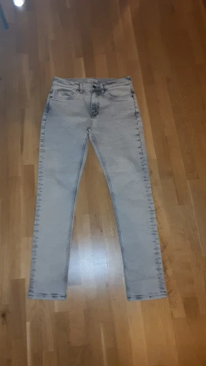 Ljusgrå gant jeans  - Snygga ljusgrå jeans med skinny passform och hög midja. Klassisk femficksdesign och diskreta slitningar vid sömmarna ger en cool vibe. Perfekta att matcha med sneakers eller boots för en trendig look. Ny pris 900