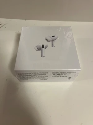 AirPods Pro (2nd generation) with MagSafe Charging Case (USB-C) - Helt nya Apple AirPods Pro (2nd generation) med MagSafe-laddningsetui (USB-C). Oöppnad originalförpackning. Aktiv brusreducering, transparensläge och adaptiv EQ för bästa ljudupplevelse. Kompatibel med iOS, iPadOS, Mac och Apple Watch.