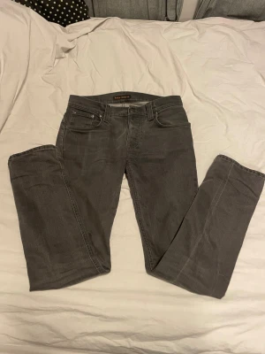 Nudie Jeans - Säljer mina mörk gråa nudie jeans. Passar perfekt och sitter riktigt bra men har växt ur dem så därför säljer jag dem. För mer frågor skriv gärna!