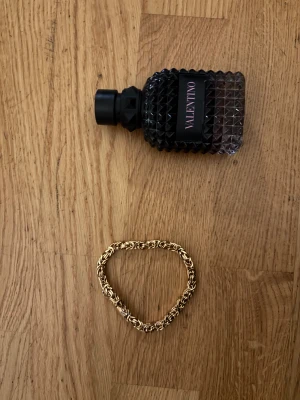 Guldigt armband med flätad kedja 14k plat - Säljer ett snyggt armband i guldton med flätad kedja och detaljerad design. Låset är robust och armbandet har en cool, chunky känsla som verkligen sticker ut. Perfekt för dig som gillar statement-smycken och vill ha något som syns.