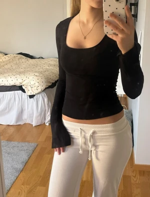 Tajt långärmad topp - Säljer en svart långärmad topp med snygg fyrkantig ringning. Modellen är tight och croppad, perfekt för dig som gillar en enkel men stilren look. Materialet känns mjukt och stretchigt, vilket gör den skön att bära hela dagen.
