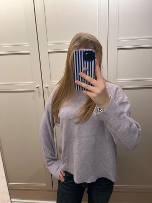 Ljuslila stickad tröja från Zara - Supermysig ljuslila stickad tröja från Zara i storlek S. Tröjan har en loose passform, ribbade muddar vid ärmslut och nederkant samt rund hals. 