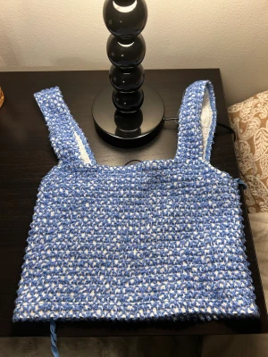 Blåvit stickad linnetopp från Zara - Säljer en blåvit stickad linnetopp från Zara. Toppen har breda axelband och är virkad i ett coolt mönster med blå och vita trådar. Perfekt för varma dagar och ger en chill vibe till din outfit.