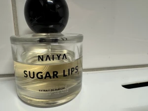 NAIYA Sugar Lips Extrait Parfum - Sugar Lips Extrait de Parfum från NAIYA – en modern och trendig doft i stilren flaska. Perfekt för dig som vill sticka ut och addera en cool touch till din stil. Mer än 30 ml kvar! 