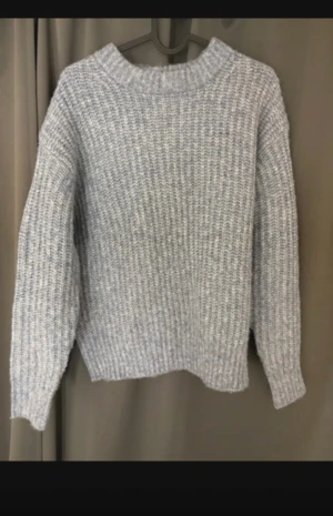 Grå stickad tröja  - Mysig grå stickad tröja med grov struktur och rund hals. Perfekt för kyliga dagar och enkel att matcha med jeans eller kjol. Långärmad och lite oversized fit för en avslappnad vibe.
