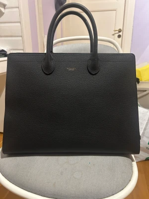 Carlheim väska Elise  - Svart väska från Carlheim. Mått: Höjd: 32 cm, Längd: 43 cm och  Vidd: 15.5 cm. Bara använd ett få antal gånger.