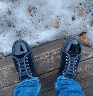 Blå sneakers från Lanvin med lackad tå - Säljer ett par snygga blå sneakers från Lanvin med cool lackad tå och mockadetaljer. Skorna har snörning och en platt sula. Perfekta för dig som vill sticka ut med en unik och stilren look.