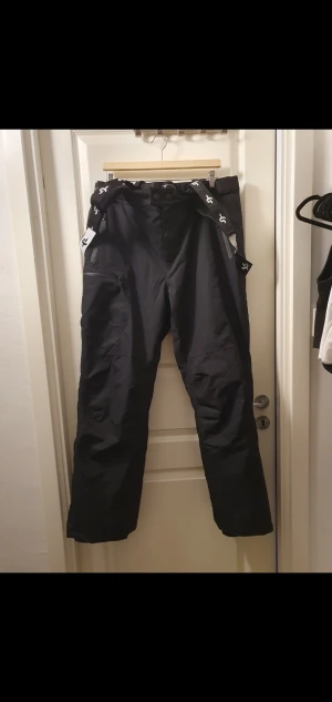 Svarta täckbyxor med hängslen - Säljer ett par svarta Skid / Snowboardbyxor med justerbara hängslen i märket Cross Sportswear strl XL. Vind och vattentät ( 10 000 mm ). Vattenlås och Justerbar midja mm!🌸 inköpt förra vintern använd 2 ggr pga fel strl !