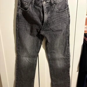 Levi's 551 Premium svarta jeans W29 L32 - Snygga Levi's Premium 551 jeans i svart tvättad denim med klassisk femficksdesign och raka ben. Jeansen har en normal passform och är tillverkade i slitstarkt bomullsmaterial. Perfekt för dig som gillar en tidlös och cool look.