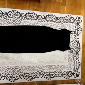 Svart långklänning från Zara - Säljer en svart långklänning från Zara med smala axelband och figurnära passform. Klänningen har en stilren och minimalistisk design som ger en elegant siluett. Perfekt för dig som gillar klassiska och tidlösa plagg.