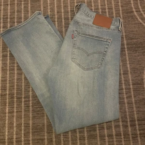 Levi's 501 ljusblå jeans straight fit - Ljusblå Levi's 501 jeans i storleken w34,L30 med klassisk femficksdesign och raka ben. Jeansen har en snygg tvättad look, Perfekta för en avslappnad stil. Hör gärna av er vid funderingar!