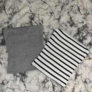 Grå topp och/ eller randig topp - Två enkla och snygga toppar, en i helgrått och en i vitt med svarta ränder. Snygga och enkla att styla eller bara att chilla i eftersom de är i väldigt mjukt och bekvämt material. Har ”klister” längst upp på kanten för att hållas uppe och inte glida ner. Köp en för 120kr eller båda för 200kr.