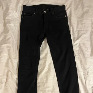 Svarta slim jeans från Weekday - Svarta jeans från Weekday, modell Friday Black Slim Jeans. Klassisk femficksdesign med silverfärgade nitar och knapp. Aldrig använda. 