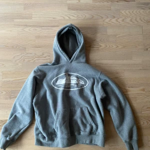 Corteiz hoodie  - Grå hoodie från Corteiz. Bra skick på denna förutom att det finns en rosa fläck (se bild 3). Fläcken kan säkert gå bort i tvätten. Storlek M men kan även passa S.