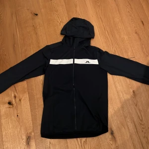 Marin blå tjoktröja från j.lindberg - Jag säljer en tjocktröja från j.lindberg. Den är som ny andvänd 2-3 gånger men var fel storlek så säljer den. Den kostar runt 2000kr ny beror på var man köper den. Den är en stilren tröja för alla olika dagar. Hör av er vid någon fråga.