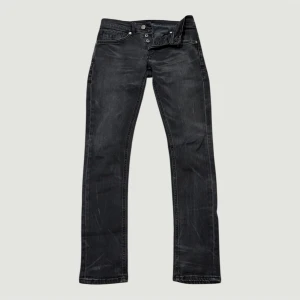 Svarta dondup george - Snygga svarta jeans från dondup med slim fit och klassisk femficksdesign. Jeansen har en diskret tvättad look, knappgylf och detaljerade bakfickor med broderad logga. Perfekta för dig som gillar stilrena och coola jeans. Jeansen har en cool selvedge tvätt.