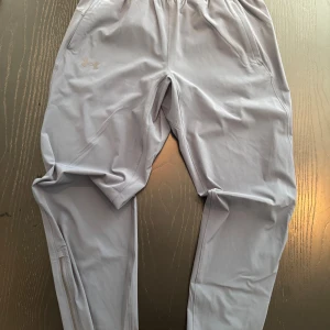 blåa träningsbyxor Under Armour L -  Under Armour med elastisk midja helt nya. Endast provade och säljs för de är för små. Storlek L men passar m då de är av modellen fitted. Splitternya.