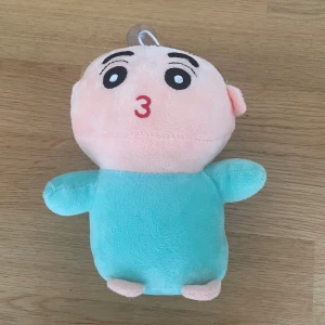 Mjukis docka  - Bilderna visar en mjukisdocka med sugpropp, troligen en leksak eller prydnad. Produkten verkar vara i gott skick utan synligt slitage.